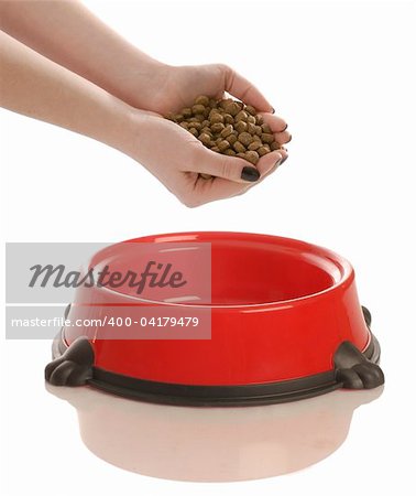 person putting hand full of dog food in a dish