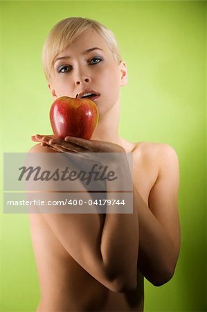 sensual blond girl with a big red apple on her hand looking in camera