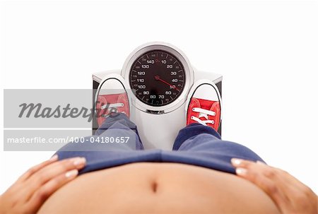 Athletic young girl measuring her weight on a balance