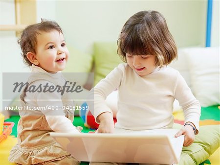 female toddler and 2-3 years old girl playing with pc in kindergarten. Horizontal shape