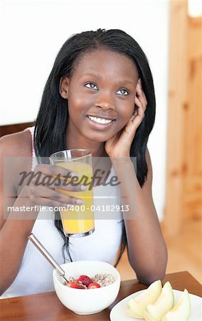 Charming Afro-American having breakfast in the living-room