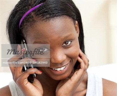 Smiling woman on phone sitting on a sofa in the living-room