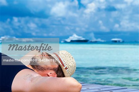 Handsome man resting near water at Maldives