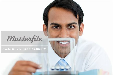 Smiling businessman playing with kinetic balls at work