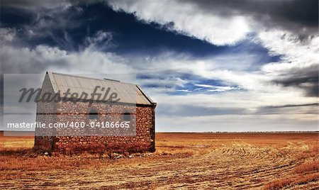 An old farm building in a sprawling field