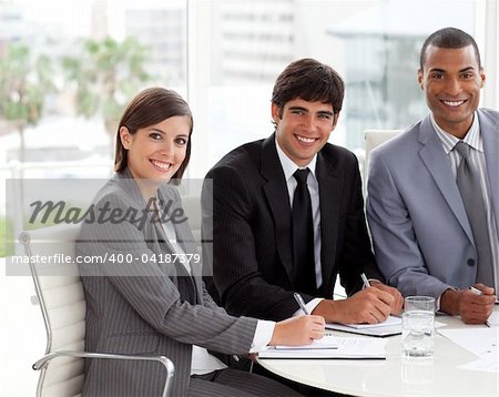 Multi-ethnic co-workers smiling at the camera in a meeting
