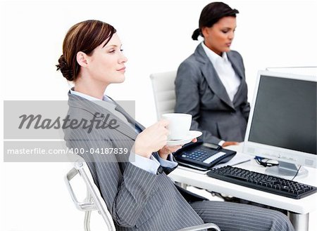 Busy female business partners drinking coffee while having a break in the office