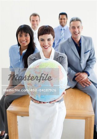 Smiling business team holding a terrestrial globe. Business concept.