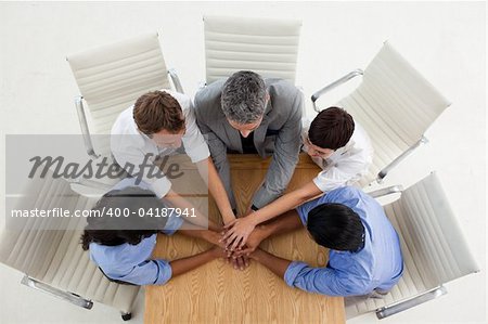 Multi-ethnic business people with hands together in a meeting