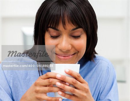 Happy businesswoman drinking a coffee in the office