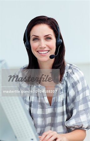 Confident businesswoman with headset on working at a computer in a call-center