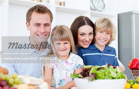 Attentive parents and their children cooking together in the kitchen