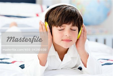 Cute boy listenning music in a bedroom