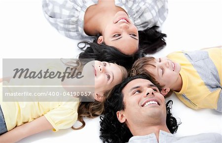 Smiling family lying on the floor together at home