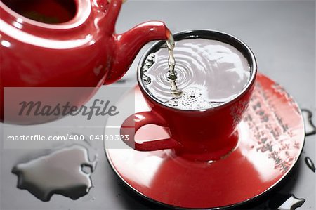 Flowing tea into red cup