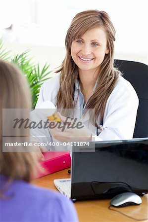 Bright female doctor holding medicine in her office