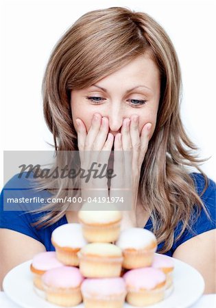 Joyful woman eating a cake against a white background