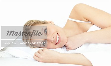 Cheerful woman relaxing lying on a bed at home