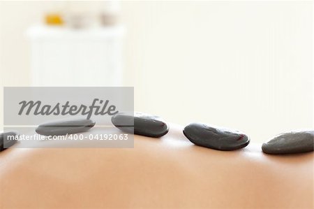 Caucasian woman lying on a massage table having a stone therapy