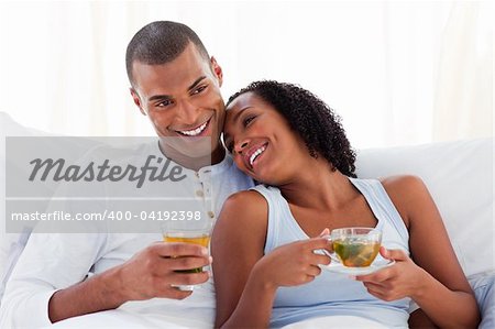 Enamoured couple cuddling lying on their bed. Concept of love.