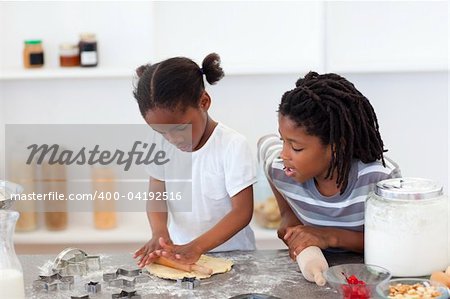 Jolly siblings cooking biscuits in the kitchen