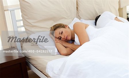 Sorrowful couple lying in the bed after having an argument