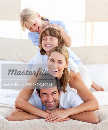 Happy family having fun in the bedroom