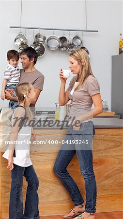 Family talking in the kitchen before going to school during breakfast