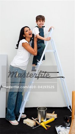 Cute little boy climbing a ladder while renovating a room