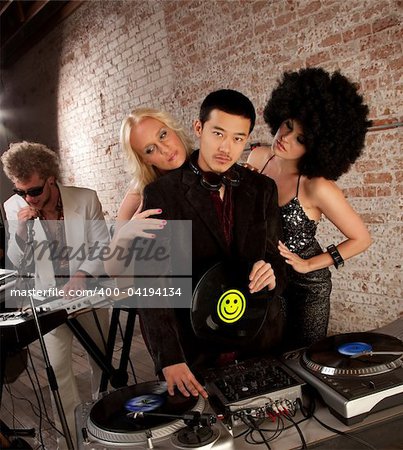 Handsome Asian DJ surrounded by admiring fans