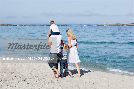 Affectionate family walking on the sand at the beach