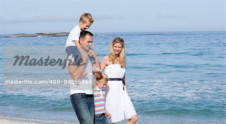 Lively family walking on the sand at the beach