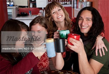 Four friends with mugs toasting at a cafe