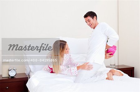 Loving husband giving a present to his wife in the bedroom