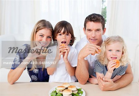 Joyful family eating breakfast in the kitchen at home