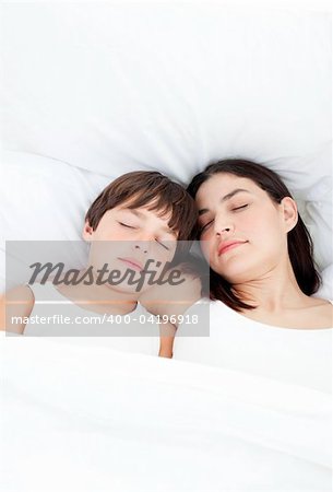 Affectionate mother and her son sleeping on a bed