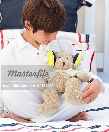 Close-up of a little boy playing with a teddy bear in his bedroom