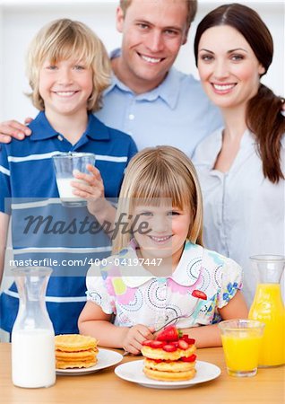 Joyful family eating breakfast in the kitchen at home