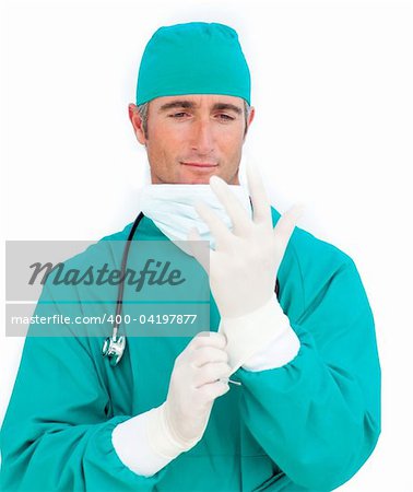 Pensive doctor looking at his surgical gloves against a white background