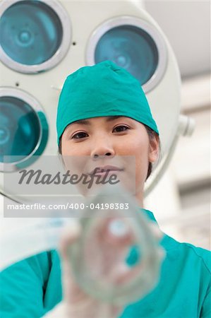 Young doctor applying oxygen mask to a patient in the hospital