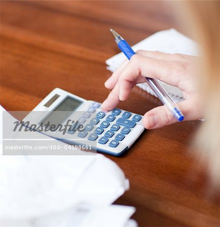 Close-up of a blond woman paying her bills on a table