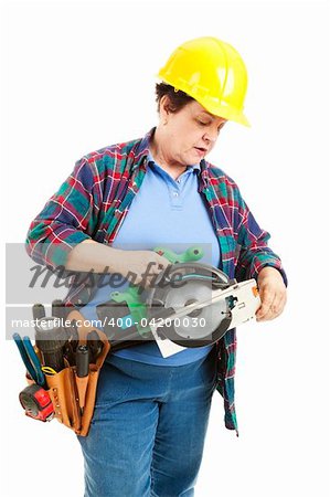 Female contruction worker trying to figure out how to use a circular saw.