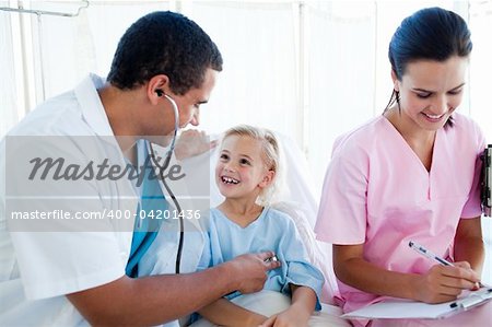 Male doctor and female nurse examining a child patient in a hospital