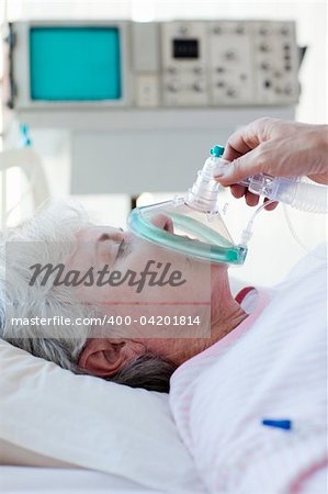 Senior patient receiving oxygen mask in a hospital