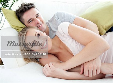 Smiling lovers having fun together on a sofa in the living-room