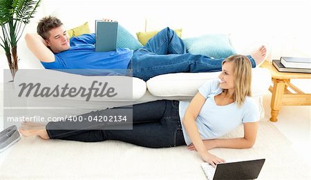 Delighted couple having free time together in the living-room