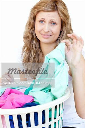 Upset woman doing laundry against a white background