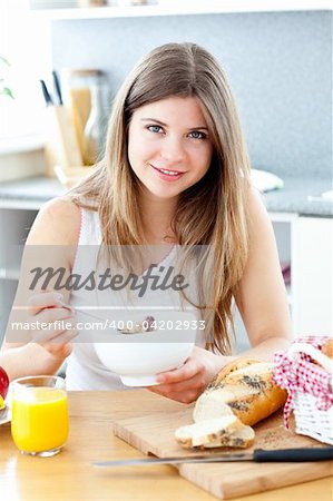 Beautiful woman eating breakfast in her kitchen