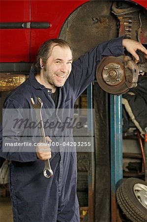 A crazy happy mechanic fixing brakes.