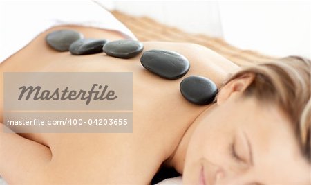 Relaxed woman with hot stones on her back in a Spa center